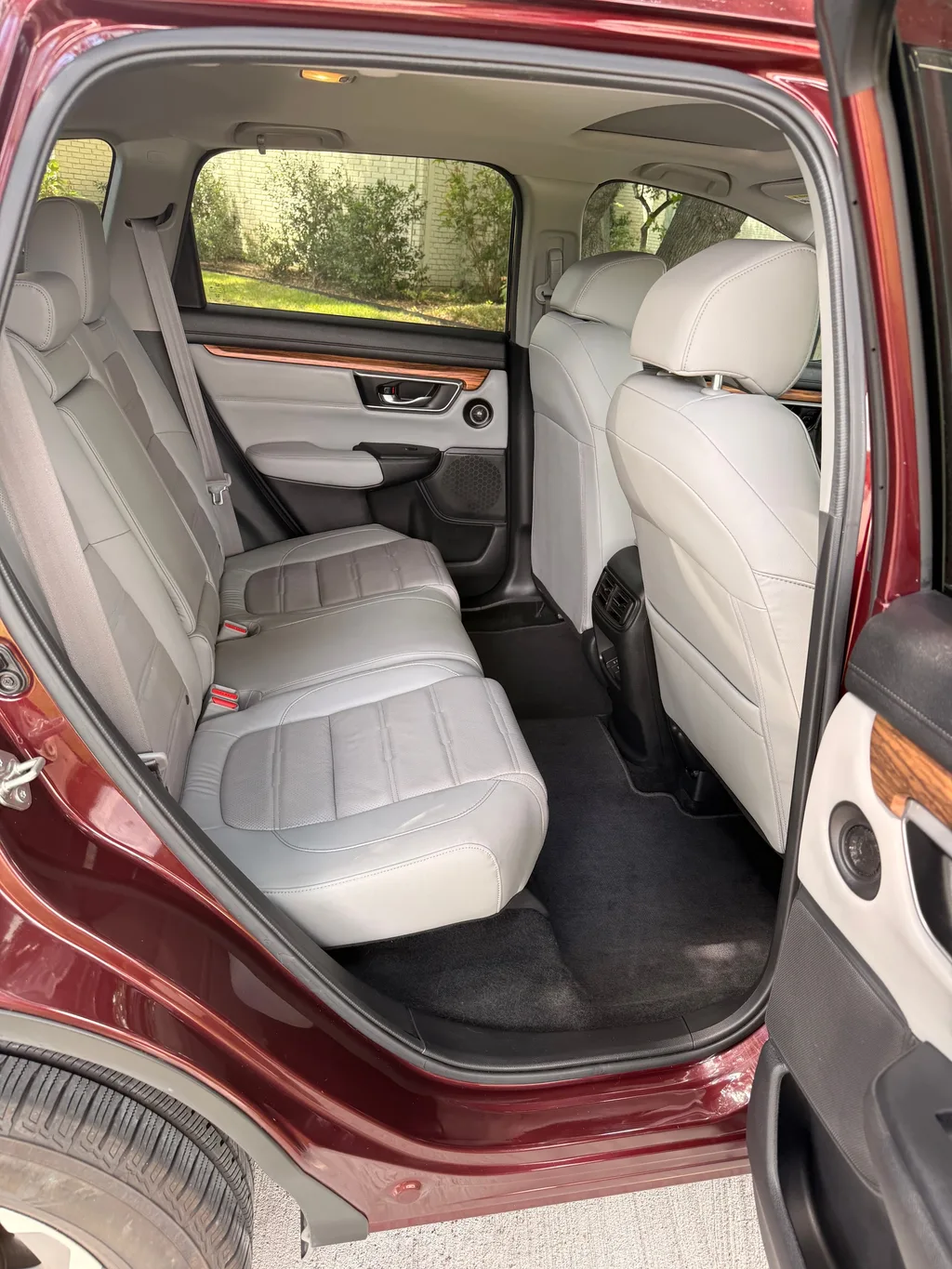 Rear seat of the red Honda CR-V after an interior detail, grey leather wiped down and the floor carpet vacuumed