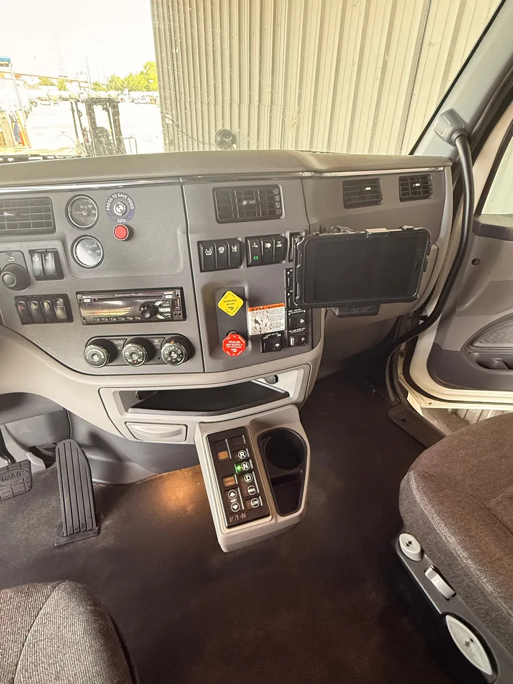 Dash and center floor of the semi truck cab after an interior detail, floor dark and clean and the dash dusted